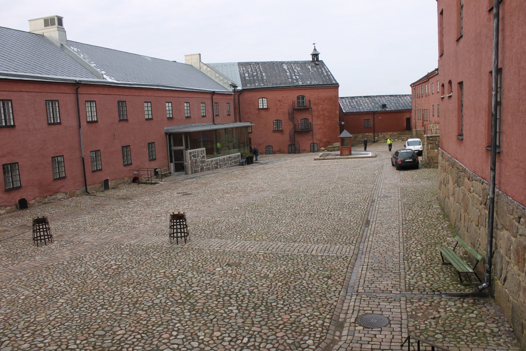 Det här är borggården på Varbergs Fästning. Vid vackert väder är det en utmärkt konsertlokal. De klassiska konsertlokalerna heter Rikssalen, som rýmmer hundratals åhörare, där man får ett pyssel med stolar, Eskils källare som rymmer kanske 30 åhörare, kaféet Kulknappen där publiken fikar, och alla valven med märklig akustik.